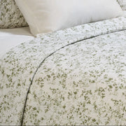 Close-up of Marjolaine quilt featuring delicate sage leaf print on white 100% cotton shell – available in Twin, Double-Queen, King, and Super King